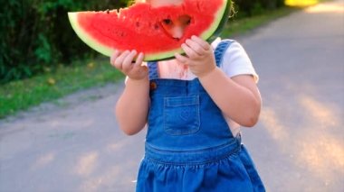 The child eats watermelon in summer. Selective focus. Kid.