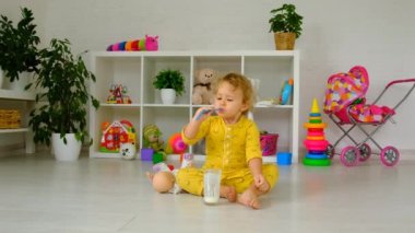 The child drinks milk in the room. Selective focus. Kid.