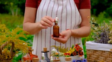 Woman makes tincture with medicinal herbs. Selective focus. Nature.
