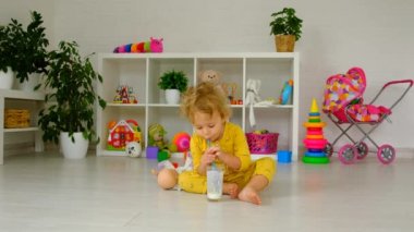 The child drinks milk in the room. Selective focus. Kid.