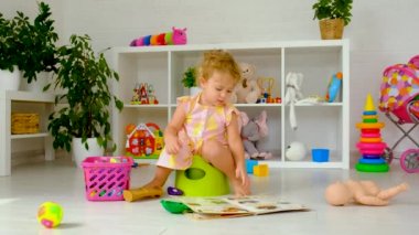 The child sits on the potty. Selective focus. Kid.