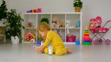 The child drinks milk in the room. Selective focus. Kid.