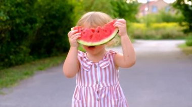 The child eats watermelon in summer. Selective focus. Kid.