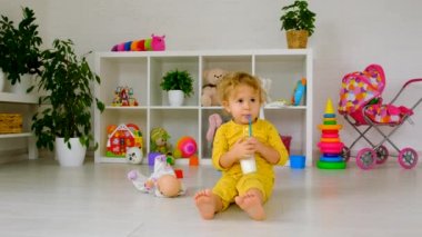 The child drinks milk in the room. Selective focus. Kid.