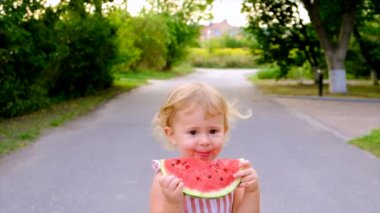The child eats watermelon in summer. Selective focus. Kid.