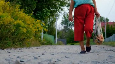 Grandmother carries vegetables in a shopping bag. Selective focus. Food.