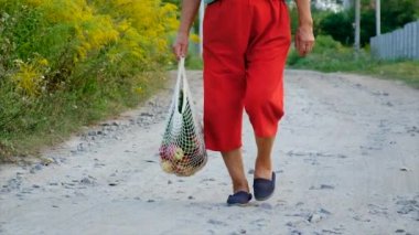 Grandmother carries vegetables in a shopping bag. Selective focus. Food.