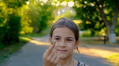 A child is studying a snail in the park. Selective focus. Nature.