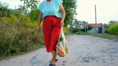 Grandmother carries vegetables in a shopping bag. Selective focus. Food.