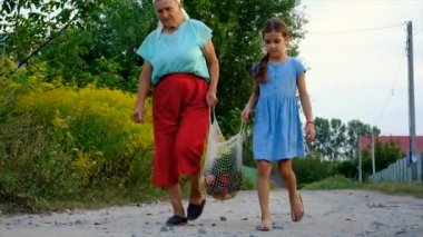 Children and grandmother carry vegetables in a bag. Selective focus. Food.