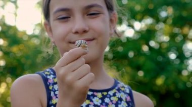 A child is studying a snail in the park. Selective focus. Nature.