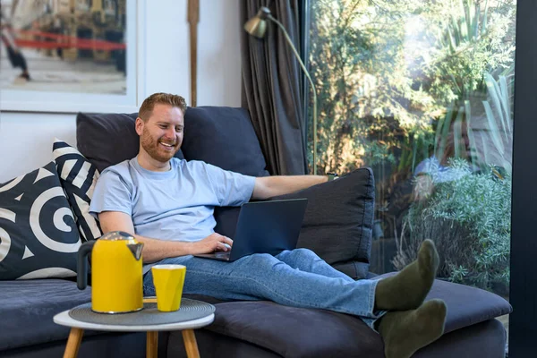 Veselý Úsměv Mladý Dospělý Muž Pohodlně Sedí Doma Velké Pohovce — Stock fotografie