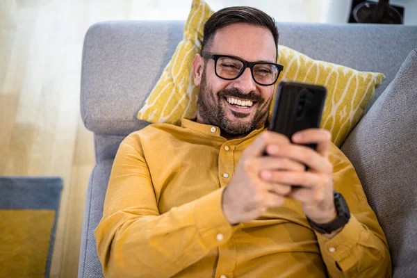 Χαρούμενος Νεαρός Ώριμος Άνδρας Χαρούμενος Χαμογελώντας Χρησιμοποιώντας Έξυπνο Τηλέφωνο Ξαπλωμένος — Φωτογραφία Αρχείου