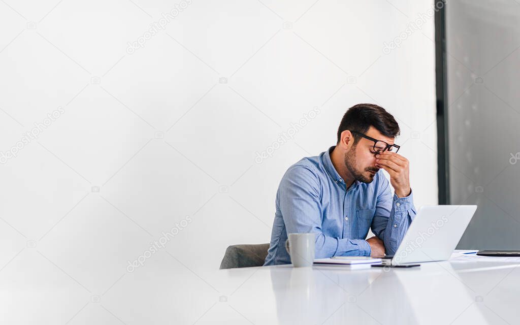 Businessman office working holding sore head pain from desk working and sitting all day using laptop computer or notebook suffering headache sick worker overworking concept