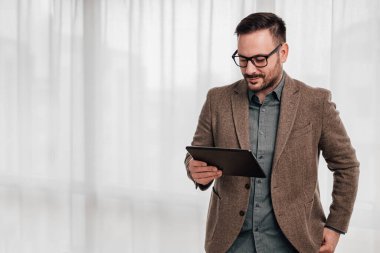 İş yerinde dijital tablet üzerinden iş planı üzerinde çalışan kendinden emin girişimci