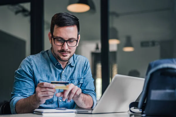 Young Male Freelancer Analyzing Credit Card While Making Online Payment — Foto Stock