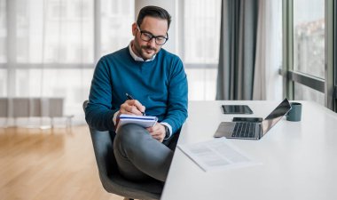 Günlüğe not alan ciddi bir iş adamı. Girişimci masa başında çalışırken strateji planlıyor. Ofiste çok şık giyiniyor..