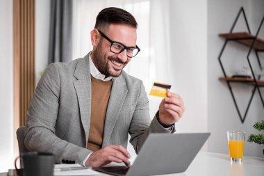 Mutlu yetişkin sakallı muhasebeci, sisteme kredi kartı bilgilerini giriyor..
