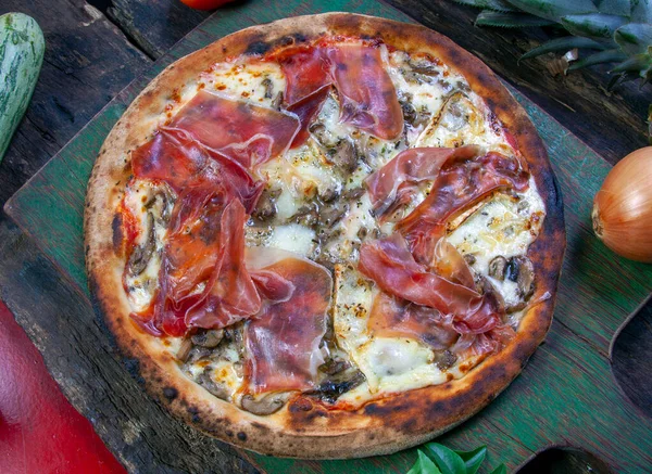 Ahşap fırında pişirilmiş Parma jambonlu pizza.