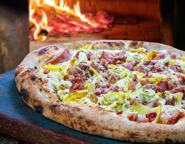 Fırında pişmiş pizza, domuz pastırması ve pırasa.