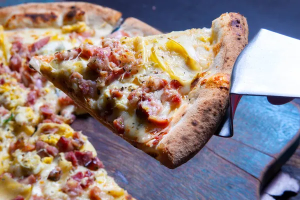 Mozzarella ve pastırmalı pizza dilimi.