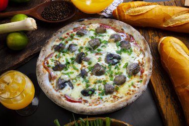 Mozzarella, domates sosu ve mantarlı pizza.