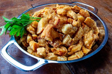 Restorandaki ahşap masada domuz derisi (torresmo). Tipik Brezilya ve Asya yemekleri.