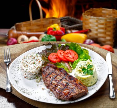 Salata, pirinç ve patates püresi ile ızgara biftek.