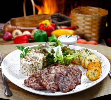 Kızarmış biftek, patates kızartması, pilav, salata.