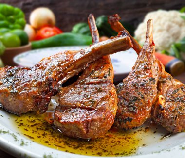 Kavrulmuş kuzu pirzolası, zeytinyağı ve bitkilerle.