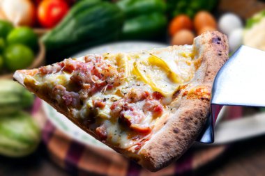 Mozzarella ve pastırmalı pizza dilimi.