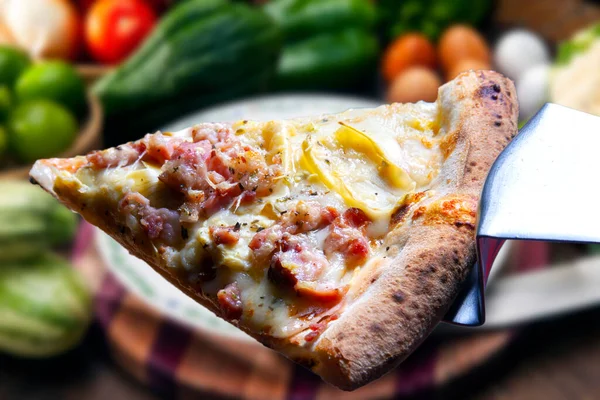 Mozzarella ve pastırmalı pizza dilimi.