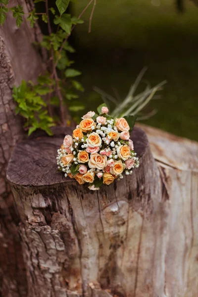 Bouquet of roses on a tree stump — Stock Photo, Image