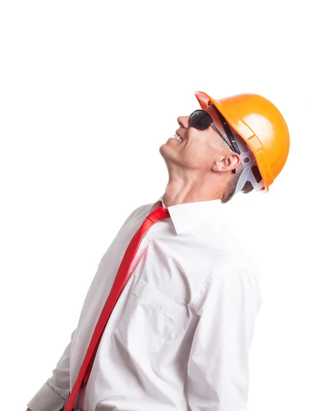 Empresário em óculos e capacete de construção olhando para cima — Fotografia de Stock