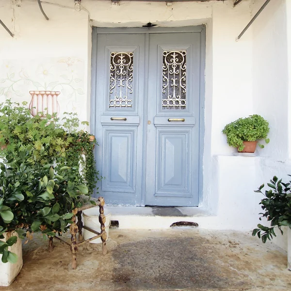 Фасад дома с серой дверью и цветочными горшками — стоковое фото