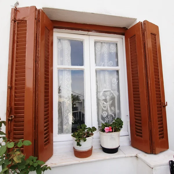 Hus fasad med brun fönsterluckor fönstret och blomkrukor — Stockfoto