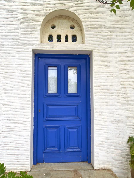 Blaue Tür mit Marmor-Bassrelief an weißer Wand — Stockfoto