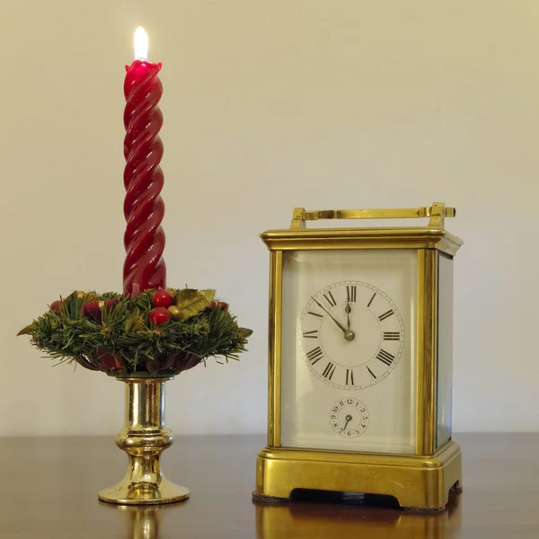 Old bronze clock and red candle — Stock Photo, Image