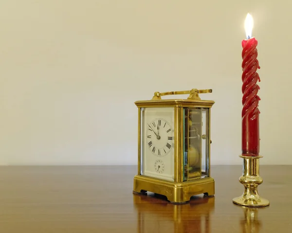 Oude bronzen klok en Rode kaars — Stockfoto