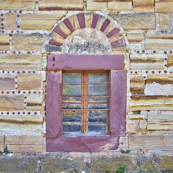 Janela arqueada na parede de pedra colorida vermelha e ocre — Fotografia de Stock