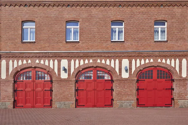 Tre röda dörrar och fyra fönster, firesquad station, centralen Europa — Stockfoto