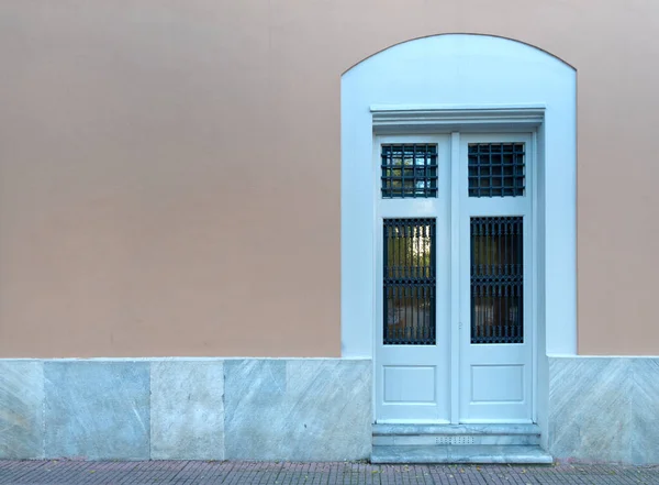 ヴィンテージアーチ型のエントランスホワイト塗装の木とガラスのドア淡い黄土色のピンクの壁 — ストック写真