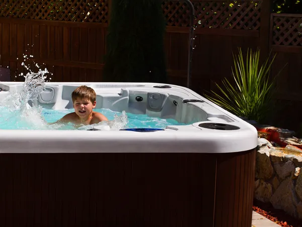 Happy boy playing in jacuzzi on the back yard — Stock Photo, Image