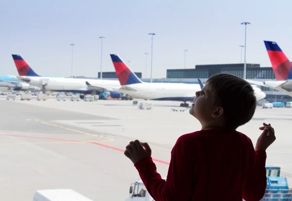 Kleiner Junge blickt am Flughafen in den Himmel — Stockfoto