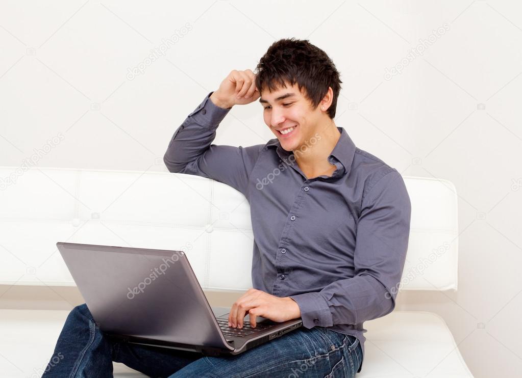 Handsome smiling man surfing the net.