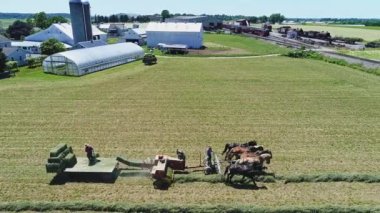 Beş Atlı Amiş çiftçilerinin, mahsullerini topladığı ve onları güzel bir günde kırsal kesime bakan bir arabaya yüklediği bir hava görüntüsü.