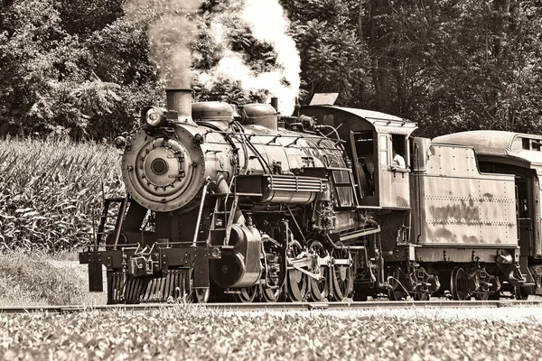 Eine Schwarz-Weiß-Ansicht eines antiken restaurierten Dampf-Personenzugs, der Rauch und Dampf bläst — Stockfoto