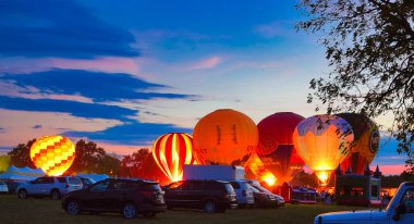 Multiple Hot Air Balloon Glow as Balloons Fire There Propane Tanks and Light Up the Balloons