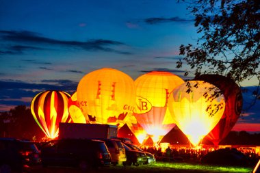 Multiple Hot Air Balloon Glow as Balloons Fire There Propane Tanks and Light Up the Balloons