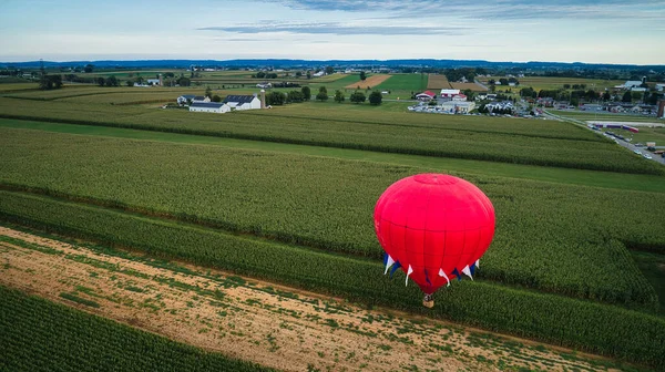 Single Hot Air Balloon Flying Just Over Corn Fields During a Balloon Festival — Fotografia de Stock